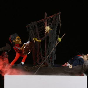 Danny McDonald, »The Crossing: Passengers Must Pay Toll In Order To Disembark (Michael Jackson, Charon & Uncle Sam)«, 2009.  Modified action figures and models, plastic, fabric, foil, Plexiglass, copper, acrylic, glitter, wood, light emitting diodes, water, and mist, 152.4 x 55.9 x 19.1 cm. Whitney Biennal 2010, Whitney Museum of American Art, New York,  25.02.10–30.05.10.