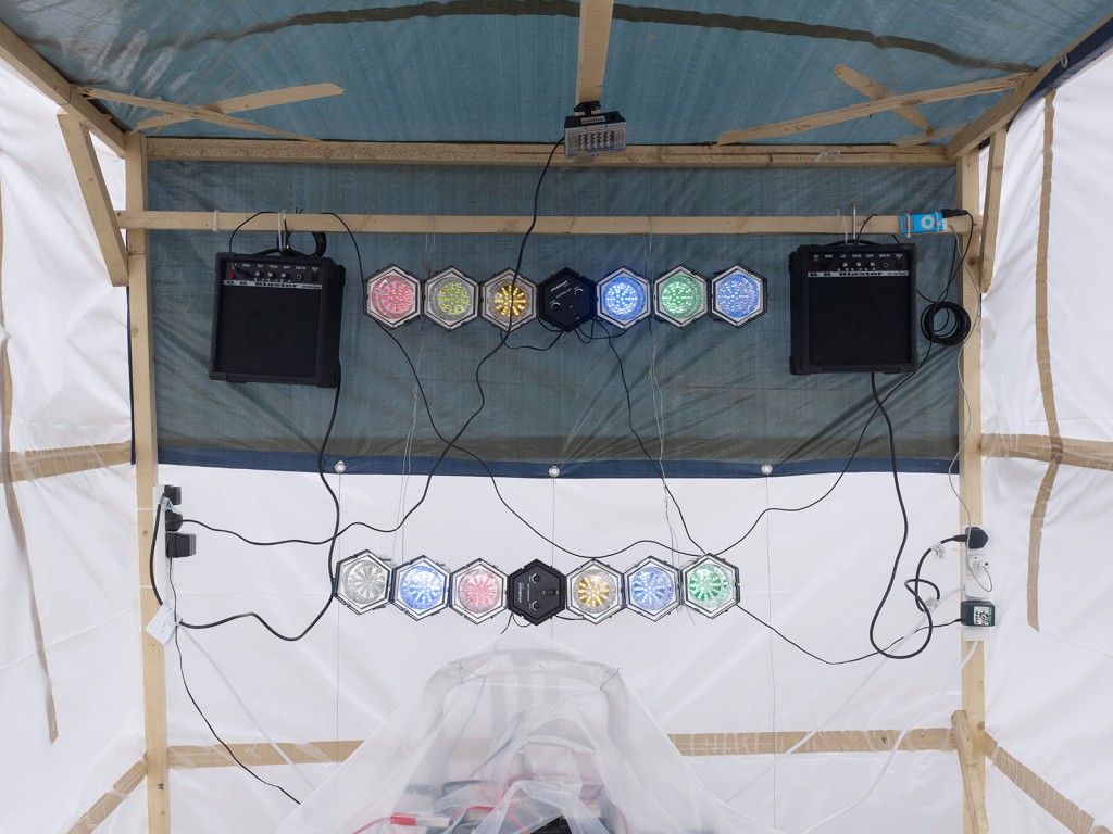 Oscar Murillo, »Make It Happen in Steps…«, 2012. Cut mirror acrylic, disco lighting, car battery, iPod shuffle, inverter, wood, plastic, cables, loudspeakers. Dimensions variable. Unique.